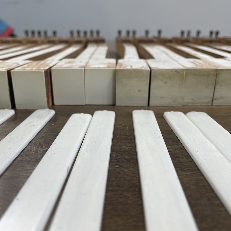 Piano keys being cleaned and getting new keytops